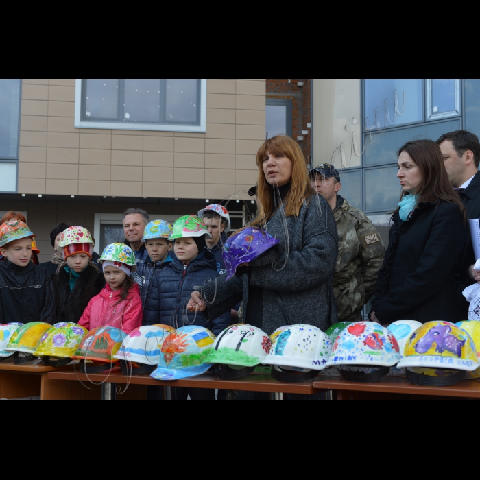 На будівельному майданчику нової лікарні «Охматдит» розпочалися роботи з облаштування покрівлі на даху блоку Д. Після 1,5-річної зупинки будівництво нової лікарні поновлюється. Маленькі пацієнти власноруч розмалювали близько 200 будівельних касок, якими і зустріли будівельників на майданчику. Також діти вручили каски членам міжфракційної депутатської групи, опікунської ради «Охматдит» та громадським активістам, які допомагають лікарні та будуть контролювати будівництво. Учасники: Оксана Корчинська, голова міжфракційної депутатської групи «За добудову Охматдит»; Ганна Гопко, член опікунської ради «Охматдит»; Юрій Гладуш, головний лікар «Охматдит»; Олена Мешкова, заст.головного лікаря «Охматдит»; Олена Анопрієнко, керівник центру медико-психологічної допомоги «Охматдит»; Олександр Солодкий, боєць 11-го батальйону «Київська Русь», волонтер; Максим Юшкевич,  боєць 11-го батальйону «Київська Русь», волонтер;  Ірина Коваль,  директор ДП «Укрмедпроектбуд»; Олеся Теліженко, дизайнер Y-футболки; маленькі пацієнти та їх батьки. 
( на передньому плані) Оксана Корчинська, голова міжфракційної депутатської групи «За добудову Охматдит», Гопко Ганна, голова Комітету Верховної Ради України у закордонних справах.