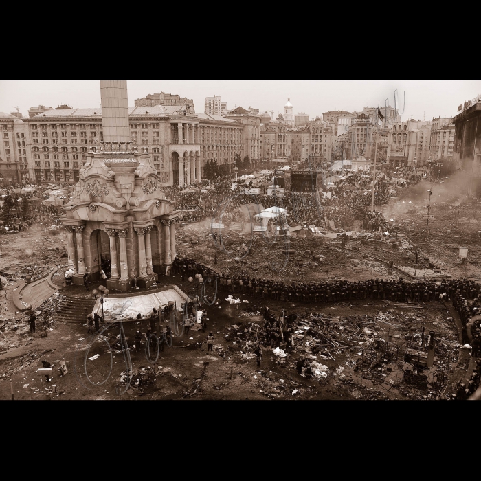 Київ. Євромайдан. Майдан Незалежності, Хрещатик. Триває протистояння на Майдані Незалежності. Активісти на Майдані Незалежності пережили важку ніч кривавих протистоянь. Новий день зустрічали гімном та піснями. Зі сцени виступають промовці, люди продовжують довбати бруківку - для захисту в разі наступу. Також активісти підтримують вогонь за допомогою покришок. За даними МОЗ України, під час сутичок у центрі Києва вже загинуло 25 осіб.