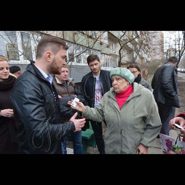 30 березня 2016 року. Київ. У столиці відбувся захід на тему «Будинки-вбивці: чому така нерухомість з’являється у столиці? Хто недопрацьовує?». Міська влада проінспектувала найбільш проблемі висотки Києва. Депутати Київради разом з представниками ЖЕКів перевірили  дахи будинків і підвали. 
Владислав Михайленко, депутат Київради, член постійної комісії Київради з питань містобудування, архітектури та землекористування розмовляє з жителькою будинку по вул Мате Залки, 4 Ніною Олександрівною Тихонюк